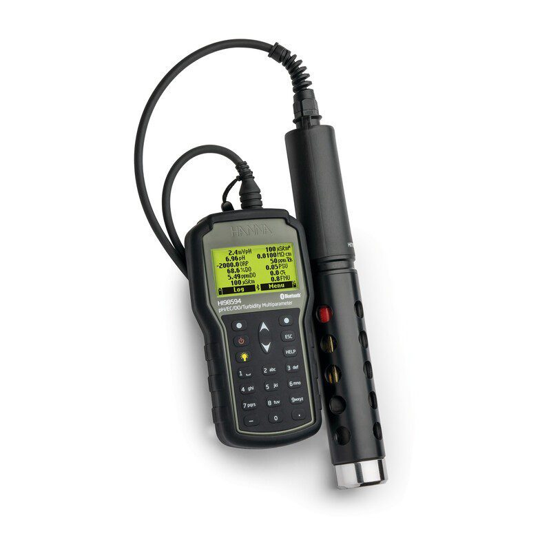 A Hanna Instruments HI98594 portable multiparameter meter resting on a white background. The dark gray handheld unit has a digital screen displaying various water quality readings and is connected by a black cable to a thick, cylindrical black multisensor probe.
